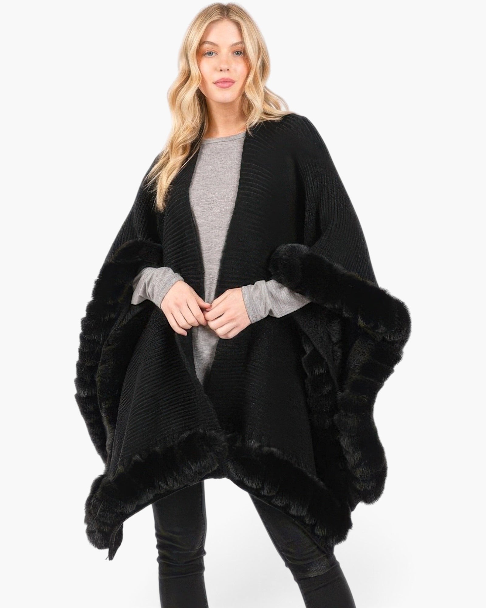 Beach Rose Co. black knit cape with plush faux fur trim and front closure worn by a blonde model
