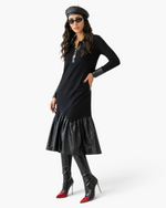 Model wearing a Beach Rose Co. black midi dress with faux leather trim, collar, and gathered hem with knee-high boots.
