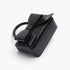 Beach Rose Co. black faux leather handbag featuring a structured silhouette and a decorative ribbon top handle.