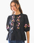 Beach Rose Co. black poplin blouse with pink and yellow floral embroidery and front ribbon ties on a model
