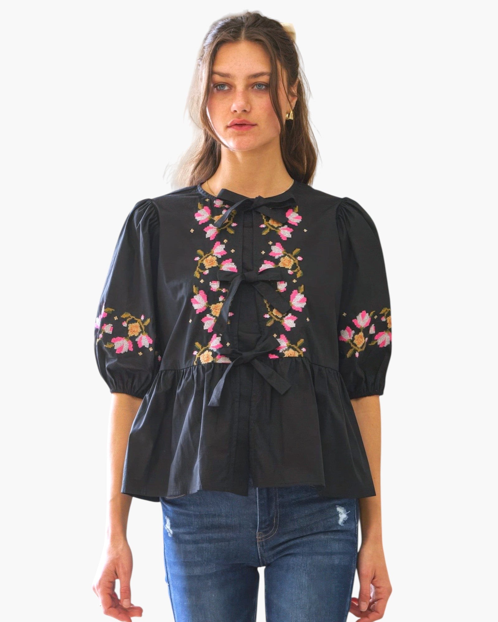 Beach Rose Co. black poplin blouse with pink floral embroidery and front ribbon ties worn by a model
