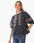 Beach Rose Co. black poplin blouse with floral embroidery, front ribbon ties, and puff sleeves worn by a model.