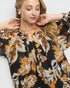 Beach Rose Co. black floral print blouse with gathered neckline and billowy sleeves, made of rayon and nylon blend.
