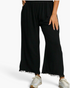 Beach Rose Co. black linen-cotton wide-leg pants with an elastic waistband, side pockets, and frayed raw-edge hems.