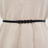 Beach Rose Co. skinny black metal waist belt featuring a geometric hexagon buckle worn over a beige ribbed sweater.