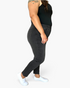 Beach Rose Co. high rise tummy control skinny jeans in black worn by a model with a black tank top and white sneakers