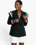 Beach Rose Co. black double-breasted blazer with white lace-trimmed shoulders worn by a smiling model.