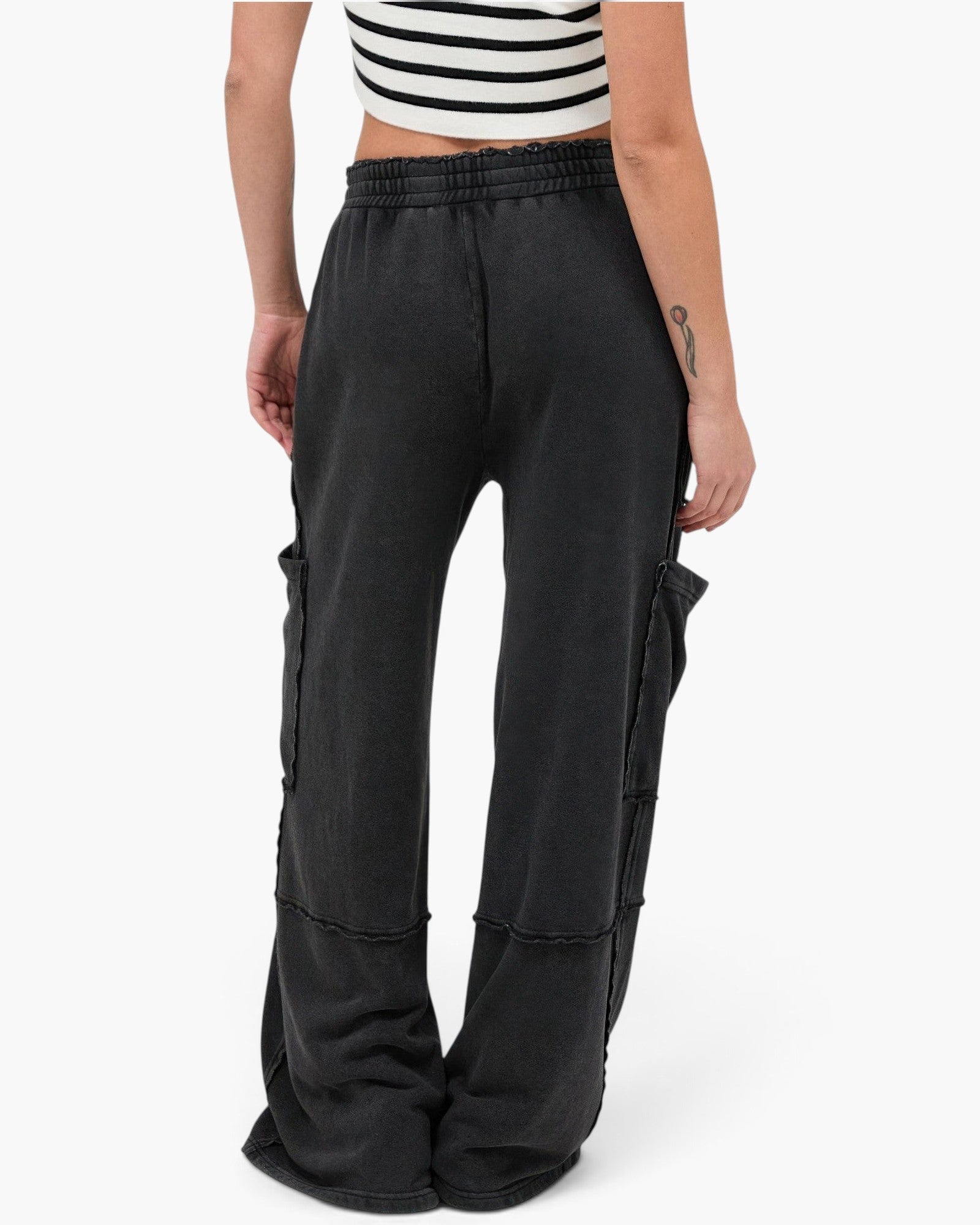 Beach Rose Co. black mineral wash wide leg cargo pants with raw edge patch pockets and elastic waistband, back view.