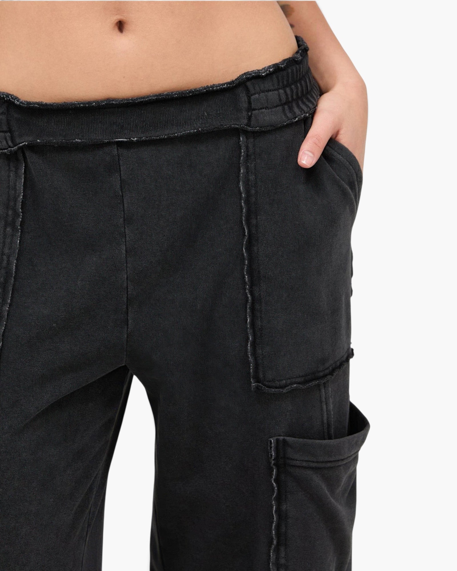 Beach Rose Co. black mineral wash cotton cargo pants with a high-rise elastic waistband and raw edge patch pockets.