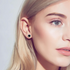 Beach Rose Co. black moissanite stud earrings with a clear zircon halo, worn by a woman with blonde hair.