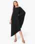 Beach Rose Co. black matte crepe one-sleeve dress with an asymmetrical hem worn by a model in beige heels.