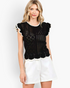 Beach Rose Co. black open-knit top with white contrast trim, ruffled cap sleeves, and a scalloped hem on a model.