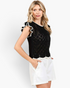 Beach Rose Co. black open-knit top with white contrast trim, ruffled cap sleeves, and a scalloped hem on a model.