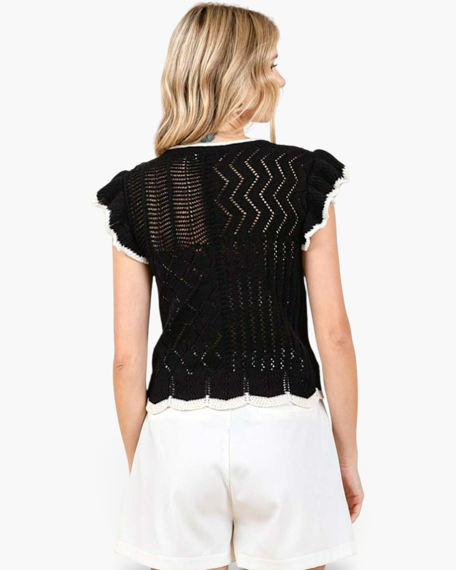 Beach Rose Co. black open-knit top with white contrast trim, ruffled cap sleeves, and a scalloped hem, back view.