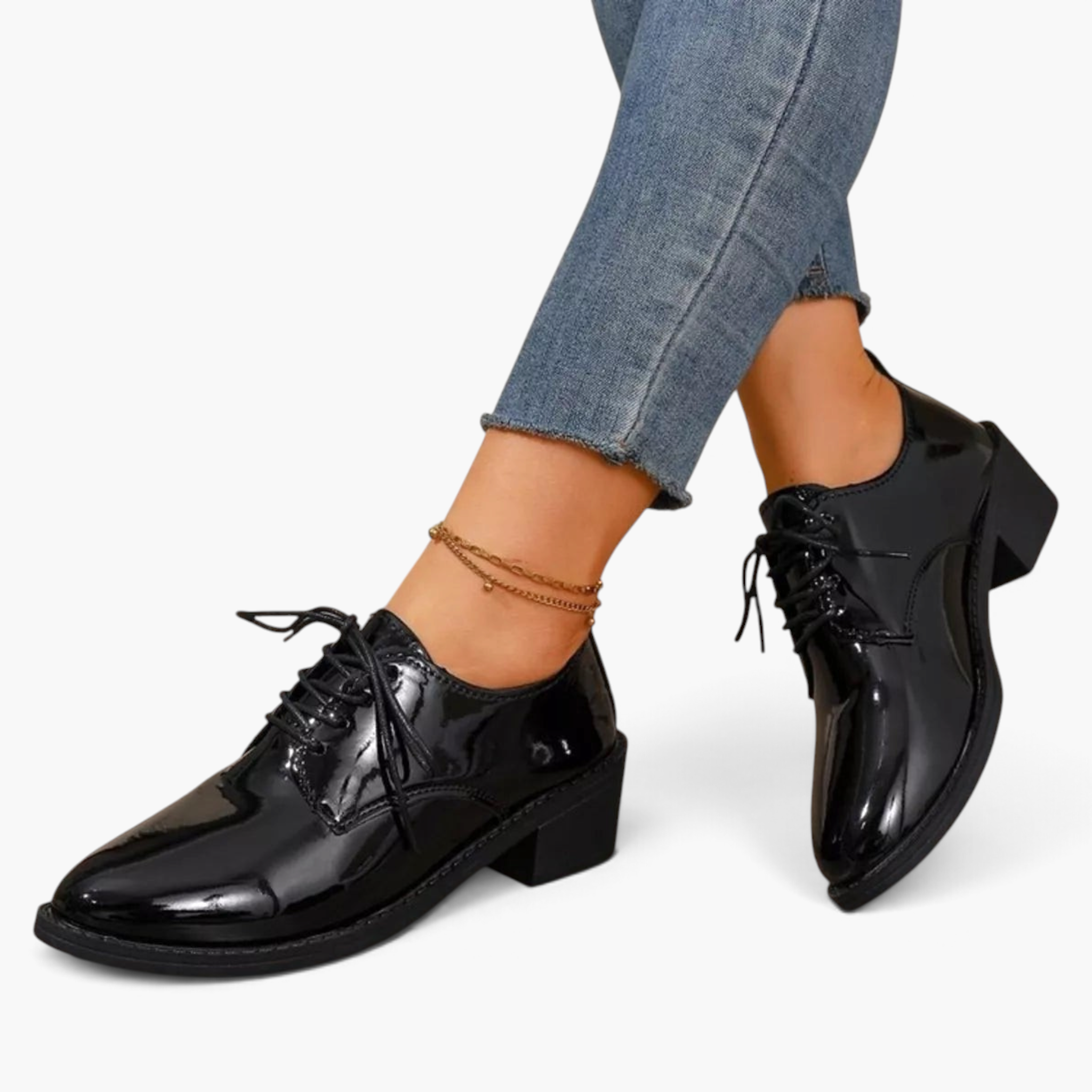 Beach Rose Co. black patent lace-up oxford shoes with a low block heel worn with cropped jeans and an ankle bracelet.
