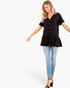 Beach Rose Co. black V-neck peplum top with button front and ruffle sleeves worn by a smiling model with blue jeans.