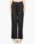 Beach Rose Co. black pleated stretch crepe wide leg pants with a high-waisted tie front design on a model.