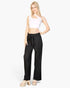 Beach Rose Co. black pleated wide-leg pants with tie-front waist worn by a blonde model in a white crop top.