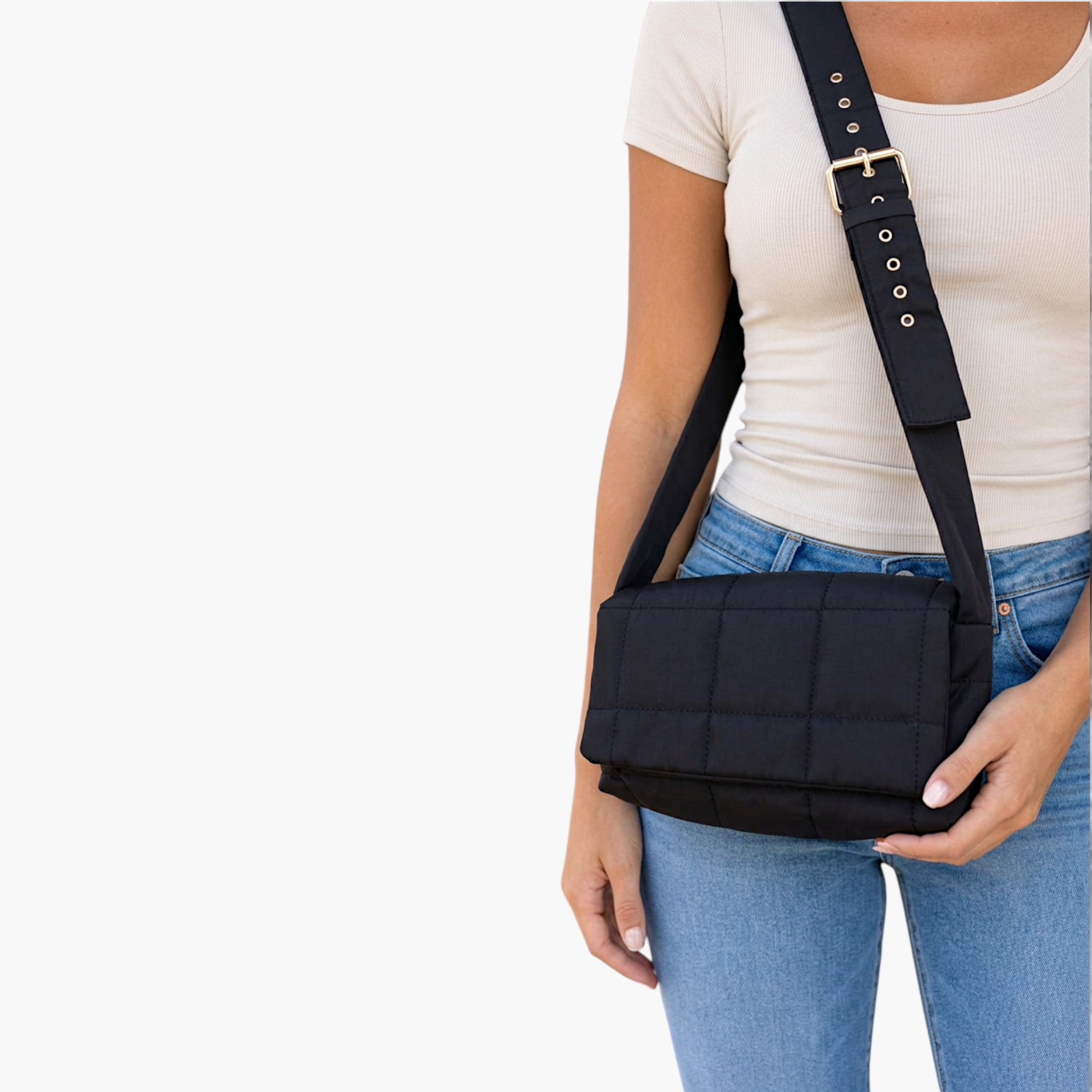 Beach Rose Co. black quilted puffer crossbody bag with wide adjustable strap and gold hardware worn by a model.