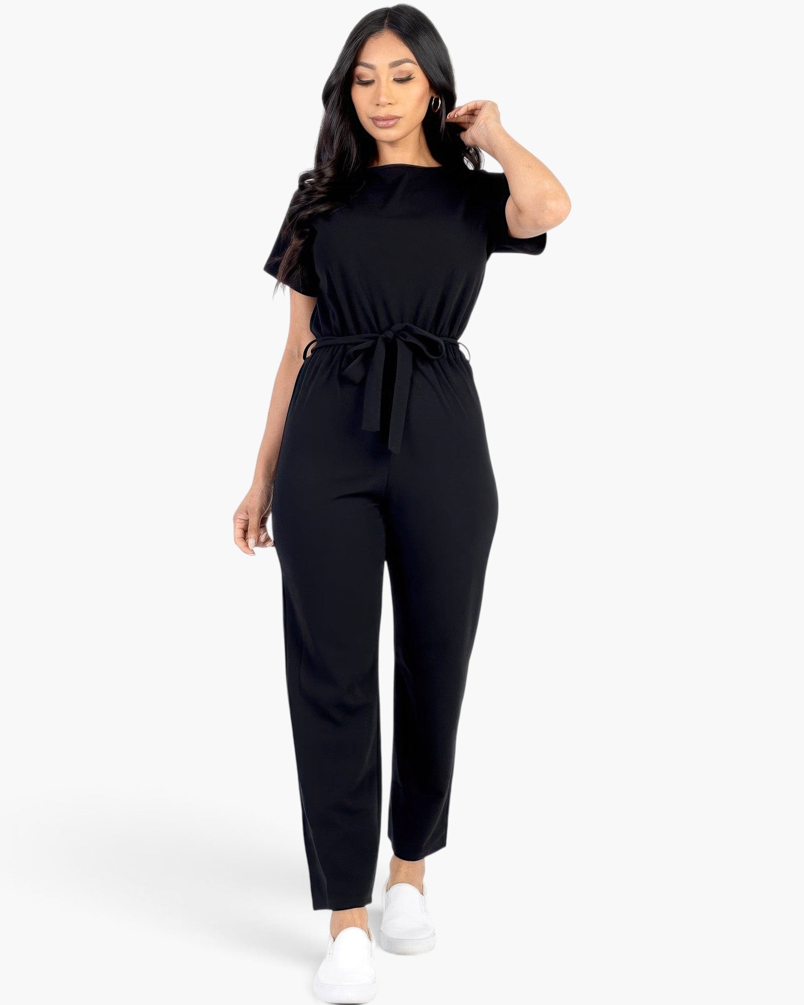 Beach Rose Co. black rib knit jumpsuit with a tie waist, short sleeves, and a relaxed fit worn by a woman.