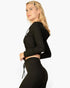 Beach Rose Co. black ribbed crop zip hoodie worn by a blonde model in a side profile view against a white background