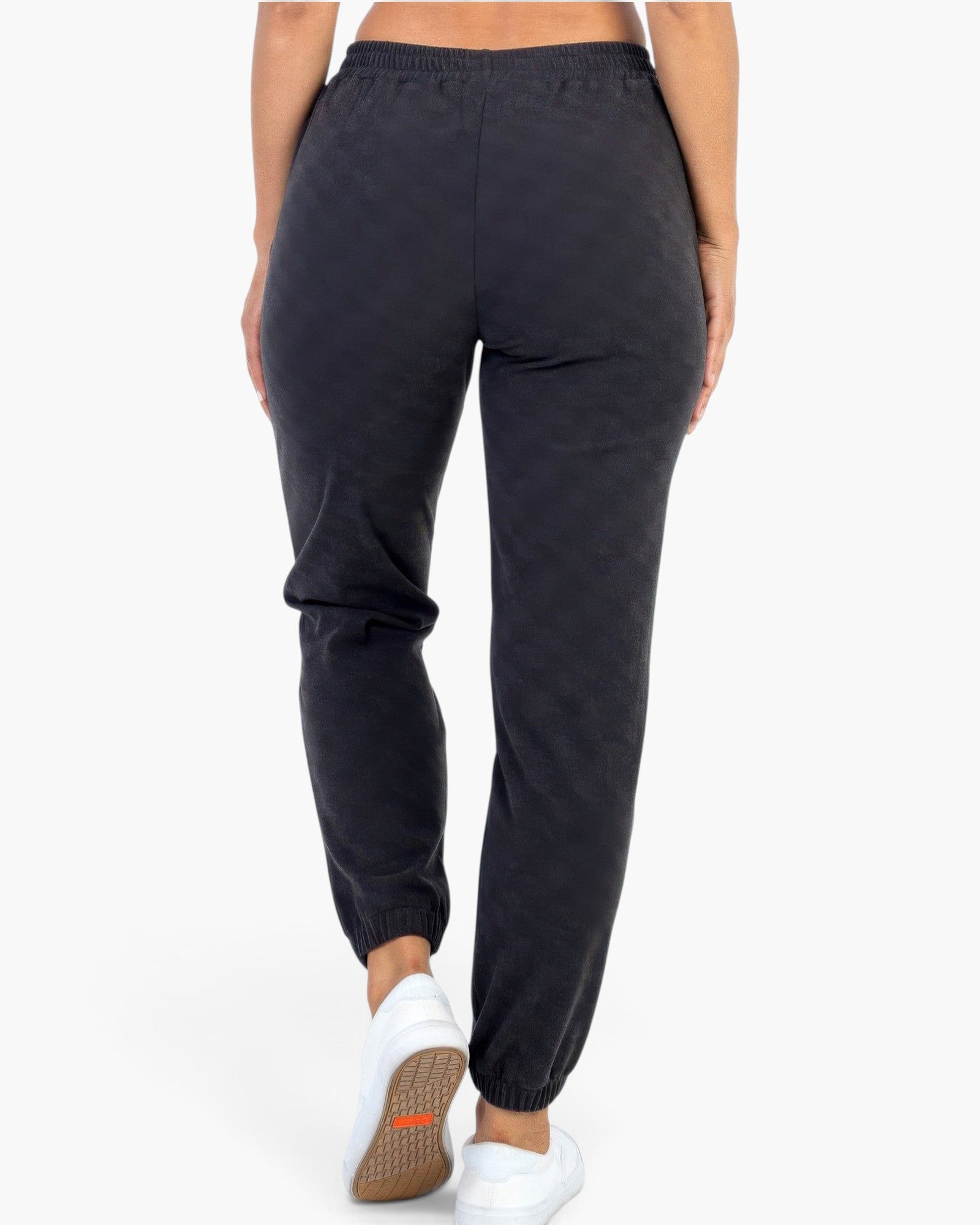 Beach Rose Co. black ribbed joggers with a relaxed fit and elastic cuffs worn by a model from the back view.