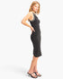 Beach Rose Co. black ribbed sleeveless cotton midi dress with white contrasting trim worn by a model in profile view.