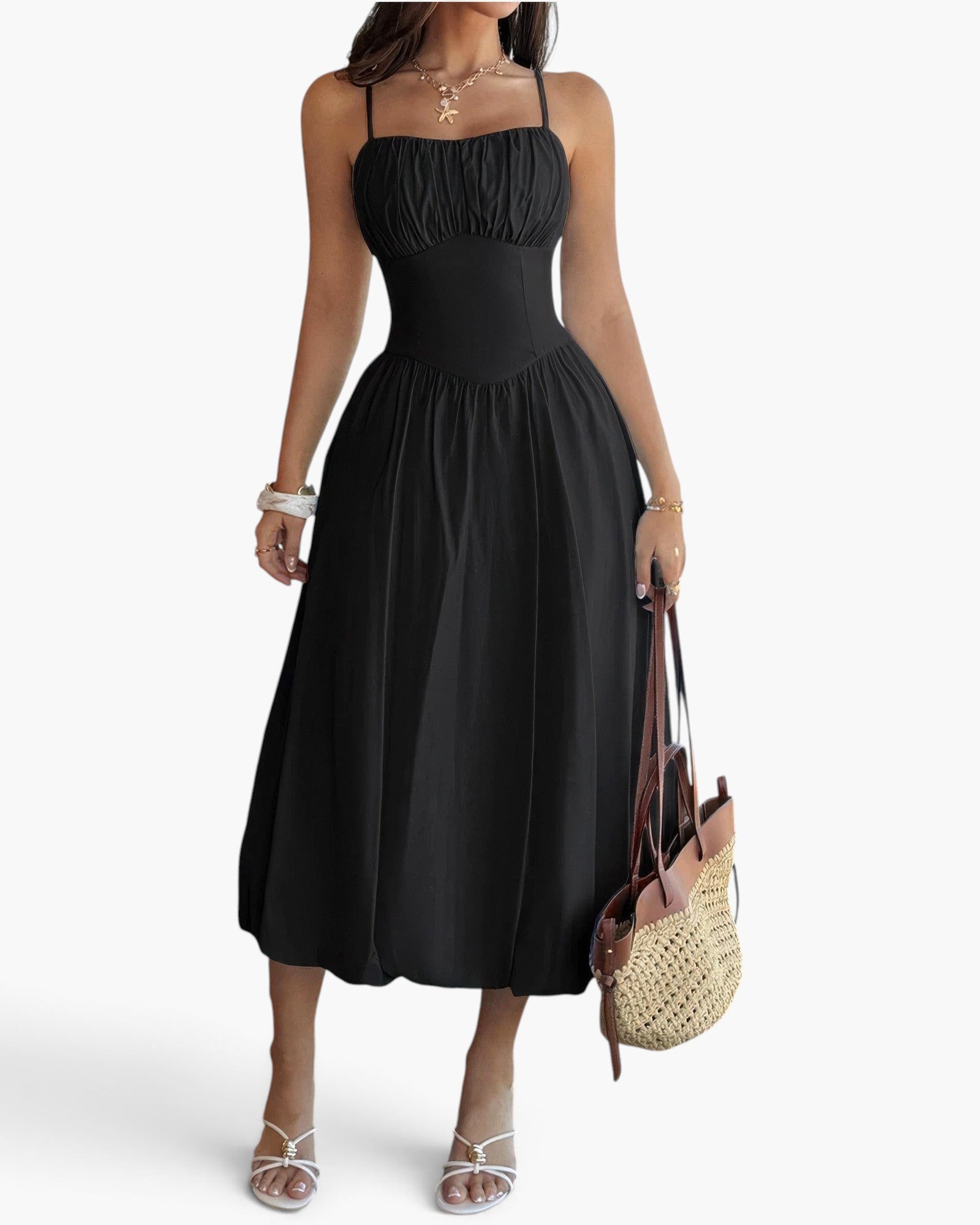 Beach Rose Co. black sleeveless A-line dress with a ruched bust, worn by a model with a straw tote bag and heels.