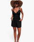 Beach Rose Co. black two-piece bikini with ruched V-neck top and shorts with pockets worn by a woman on the beach