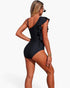 Beach Rose Co. black one-piece swimsuit with an asymmetrical shoulder ruffle and stretch fabric, back view.