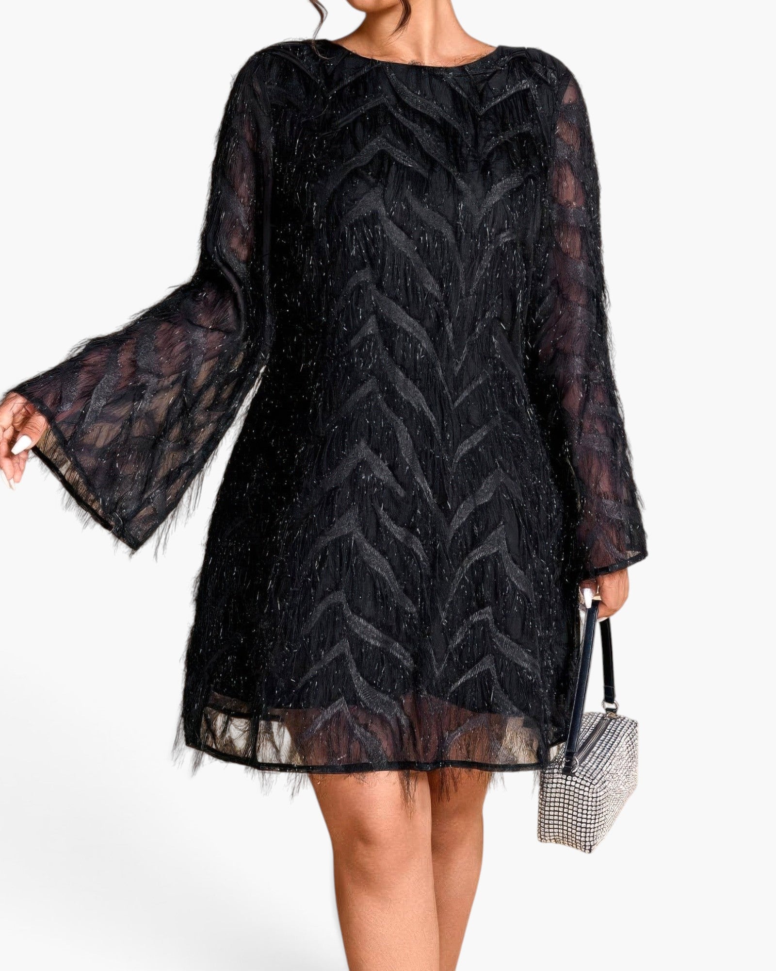 A woman wearing a black sheer lace dress with long bell sleeves and a chevron pattern, holding a small rhinestone handbag against a plain white background.