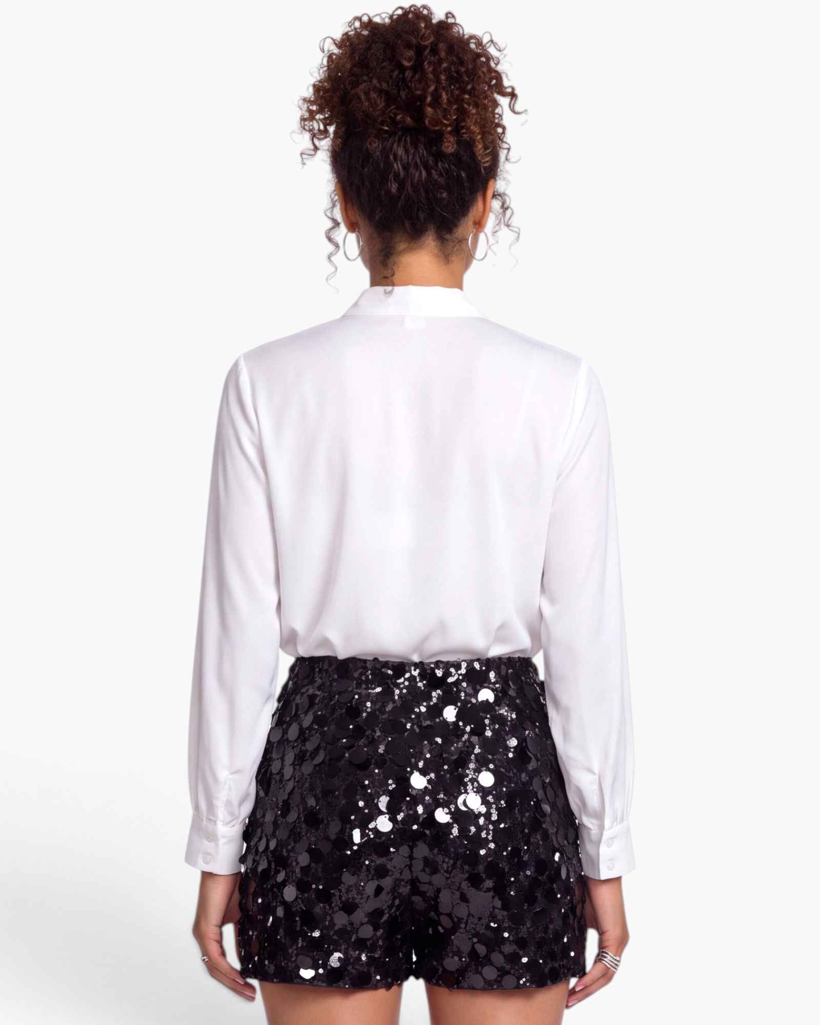 Beach Rose Co. black sequin shorts with mixed-size disc embellishments, back view on model.