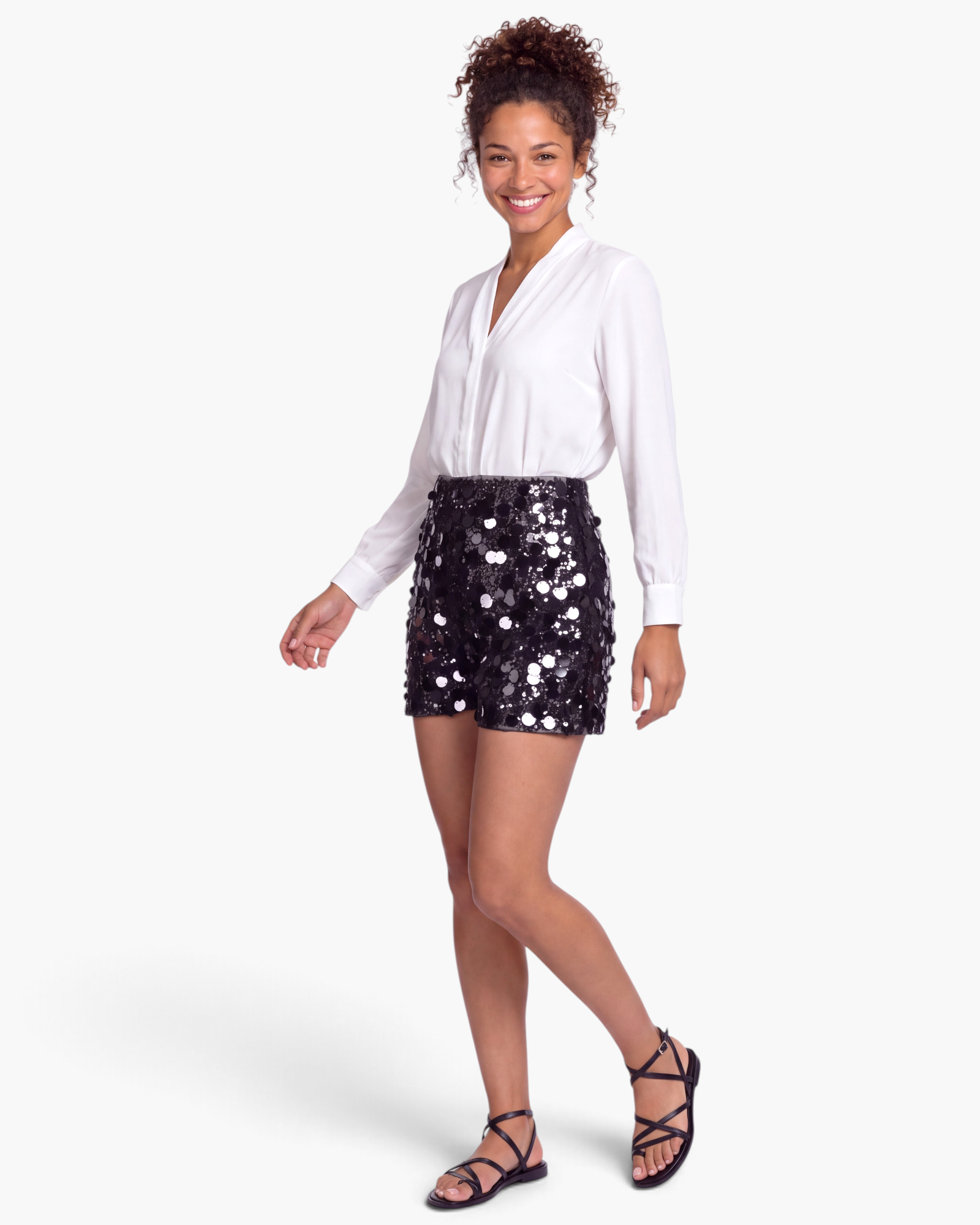 Beach Rose Co. black sequin shorts with mixed-size discs worn with a white blouse and sandals.