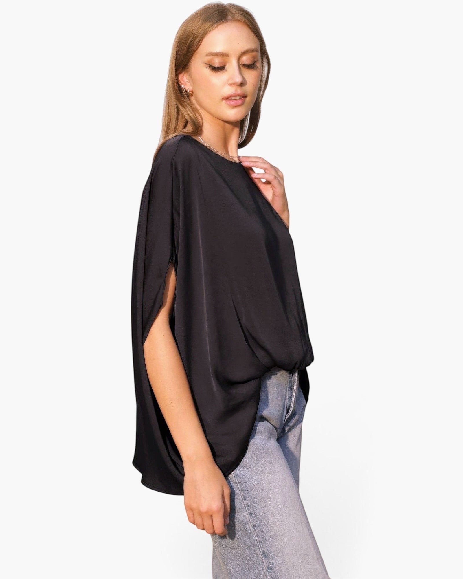 Beach Rose Co. black washed poly silk caftan top with boat neck and flowy sleeves worn by a model with light jeans