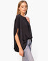 Beach Rose Co. black washed poly silk caftan top with boat neck and flowy sleeves worn by a model with light jeans