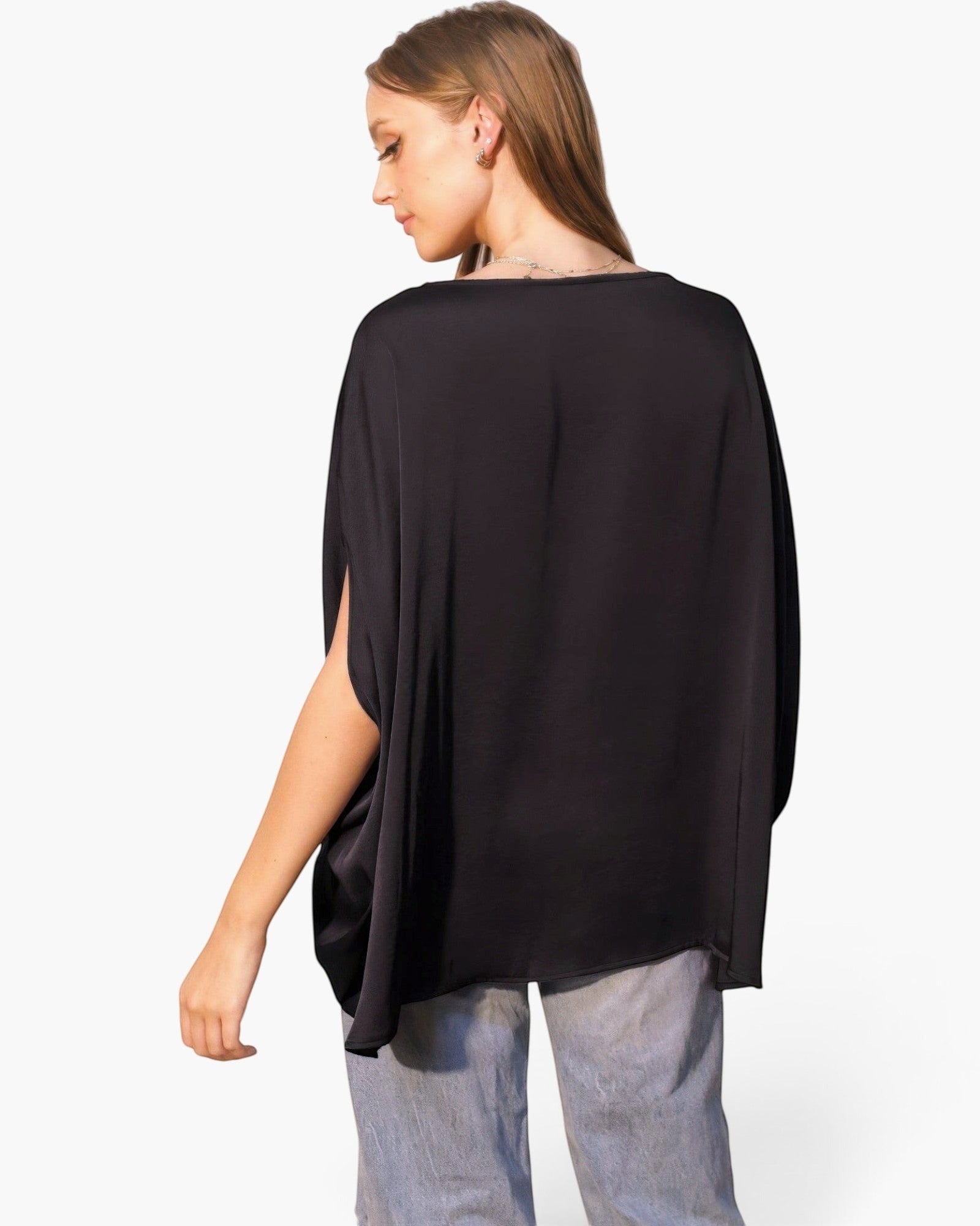 Model wearing a black Beach Rose Co. washed poly silk boat neck caftan top with flowy sleeves and elasticized waist.