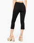 Beach Rose Co. black cropped pants with a slit hem detail, worn by a model in beige platform mules, back view.