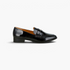 Beach Rose Co. black patent pleather penny loafers with stud embellishments on the strap and a low block heel.