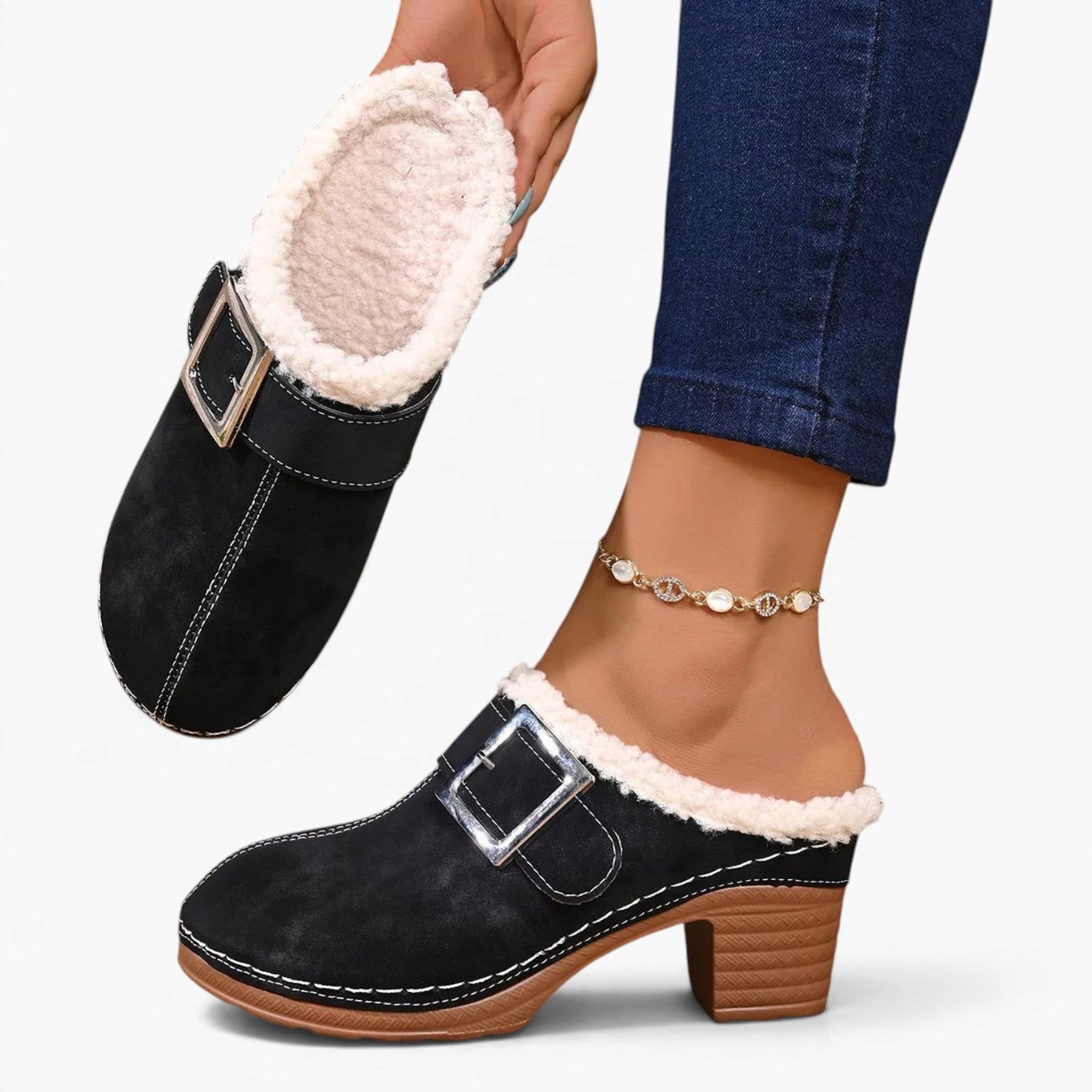 Beach Rose Co. black suede clogs with fluffy white trim, oversized buckle, and chunky block heel on a model's foot.