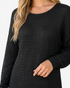 Beach Rose Co. black textured knit sweater dress with a round neckline and long sleeves on a model