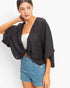 Beach Rose Co. black oversized twist knot top with V-neck and loose sleeves worn over a white camisole