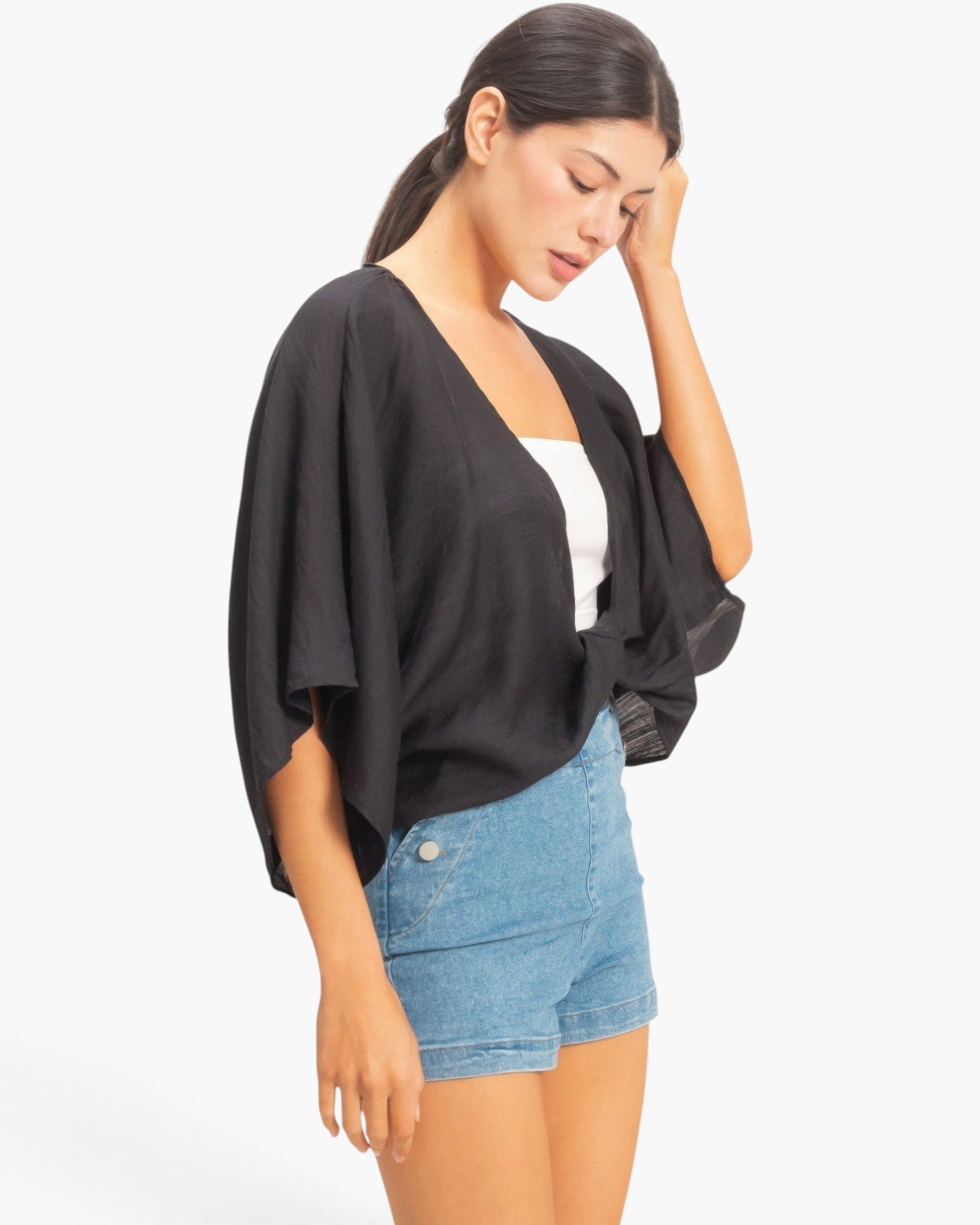 Beach Rose Co. black oversized twist knot top with V-neck and loose sleeves worn by a model with denim shorts