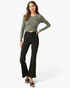 Beach Rose Co. black high-rise flare pants with a crossover V-waist worn by a model with a long-sleeve olive top.