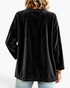 Back view of a Beach Rose Co. black velour cardigan with a relaxed fit and dropped shoulders on a model.