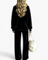 Beach Rose Co. black velour two-piece set with a relaxed crewneck top and wide leg pants, worn by a blonde woman.