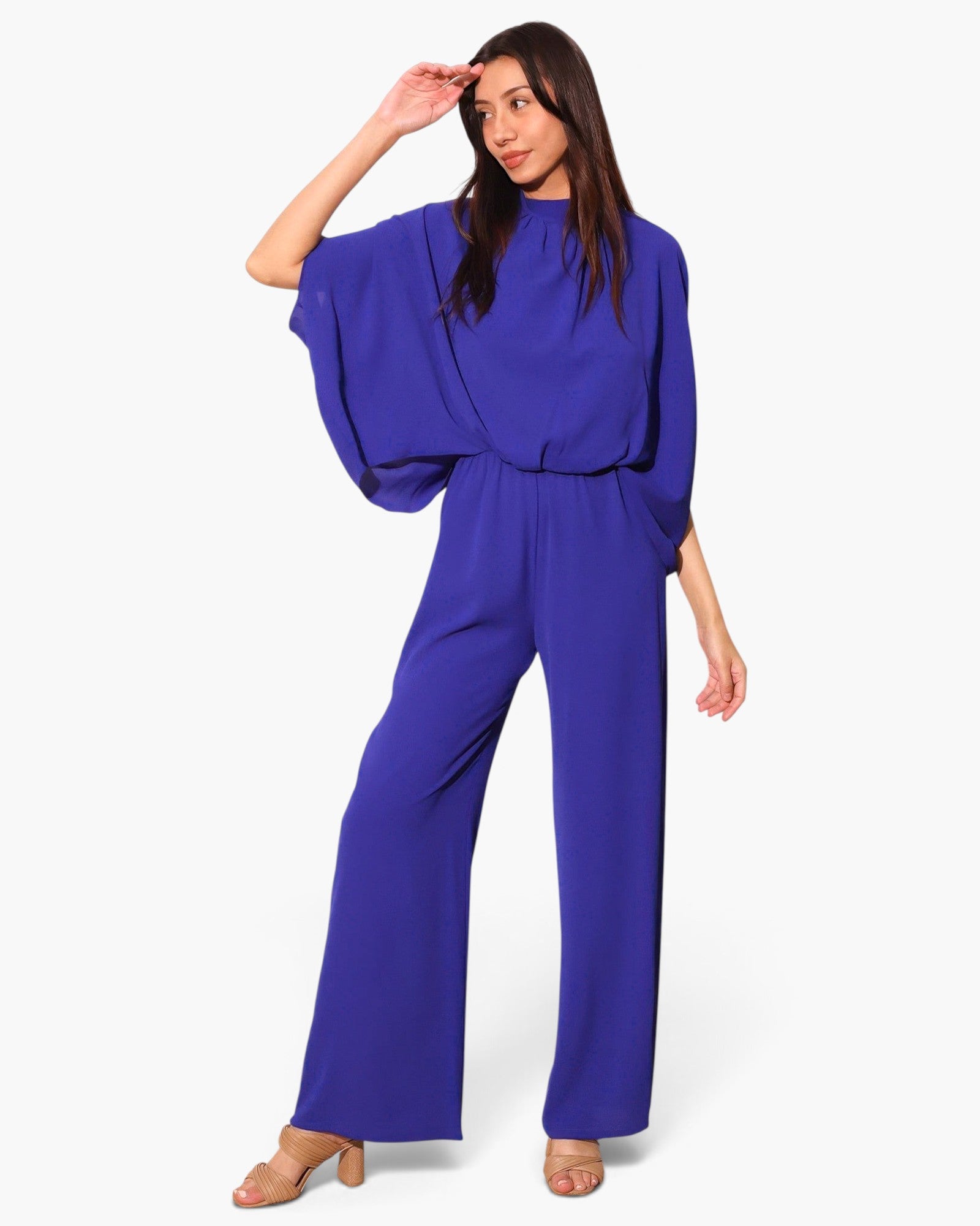 Model wearing a Beach Rose Co. royal blue textured mock neck caftan jumpsuit with wide legs and flowing sleeves.