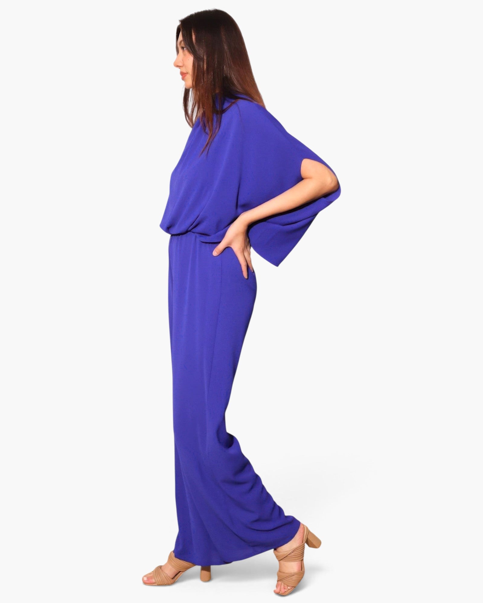 Model wearing a Beach Rose Co. royal blue textured mock neck caftan jumpsuit with wide sleeves and a fluid silhouette.