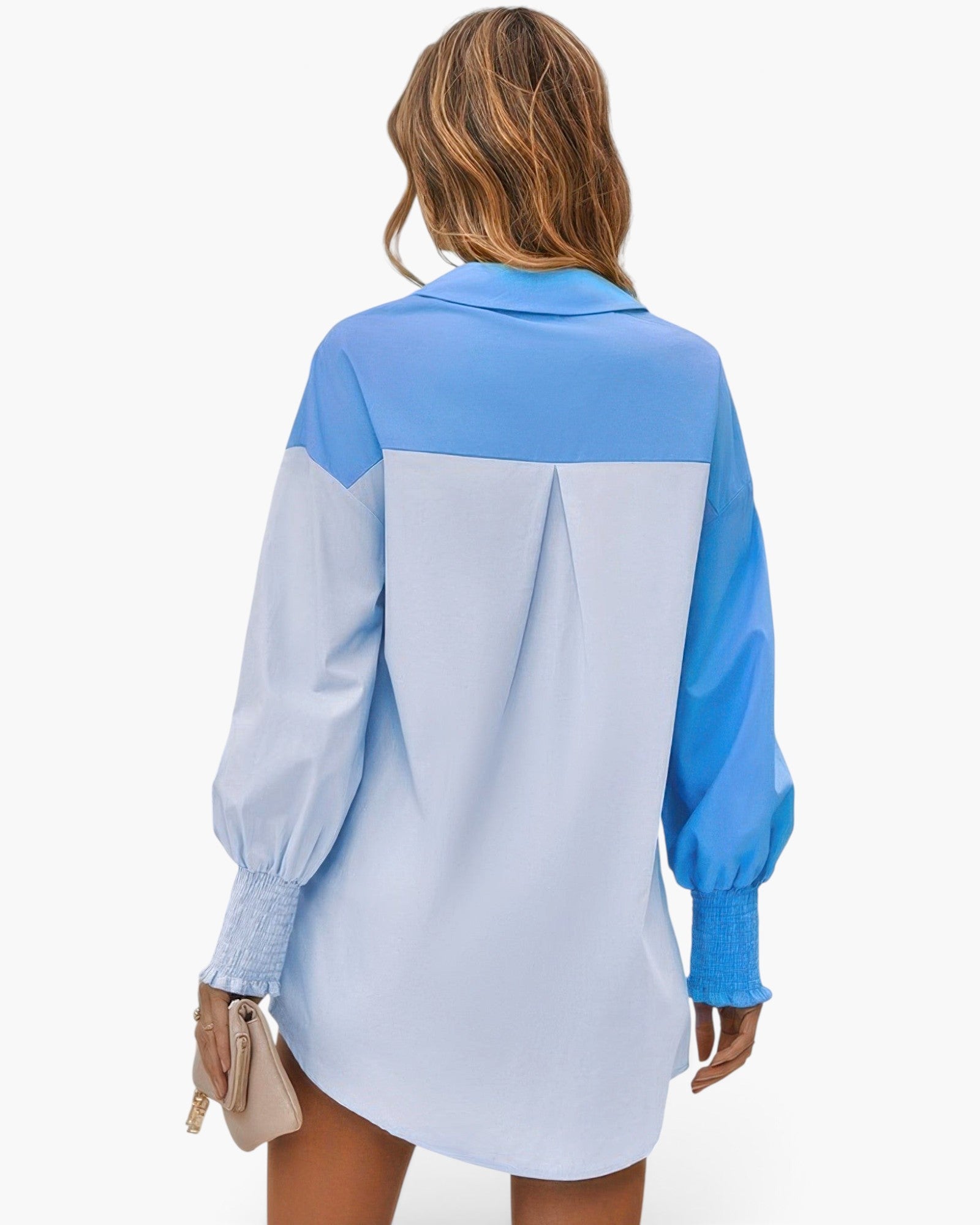 Beach Rose Co. blue color block button down blouse with cuffed sleeves worn by a woman, back view.