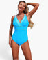 Beach Rose Co. blue color block one-piece swimsuit with a V-neckline and stretch fabric worn by a smiling woman.