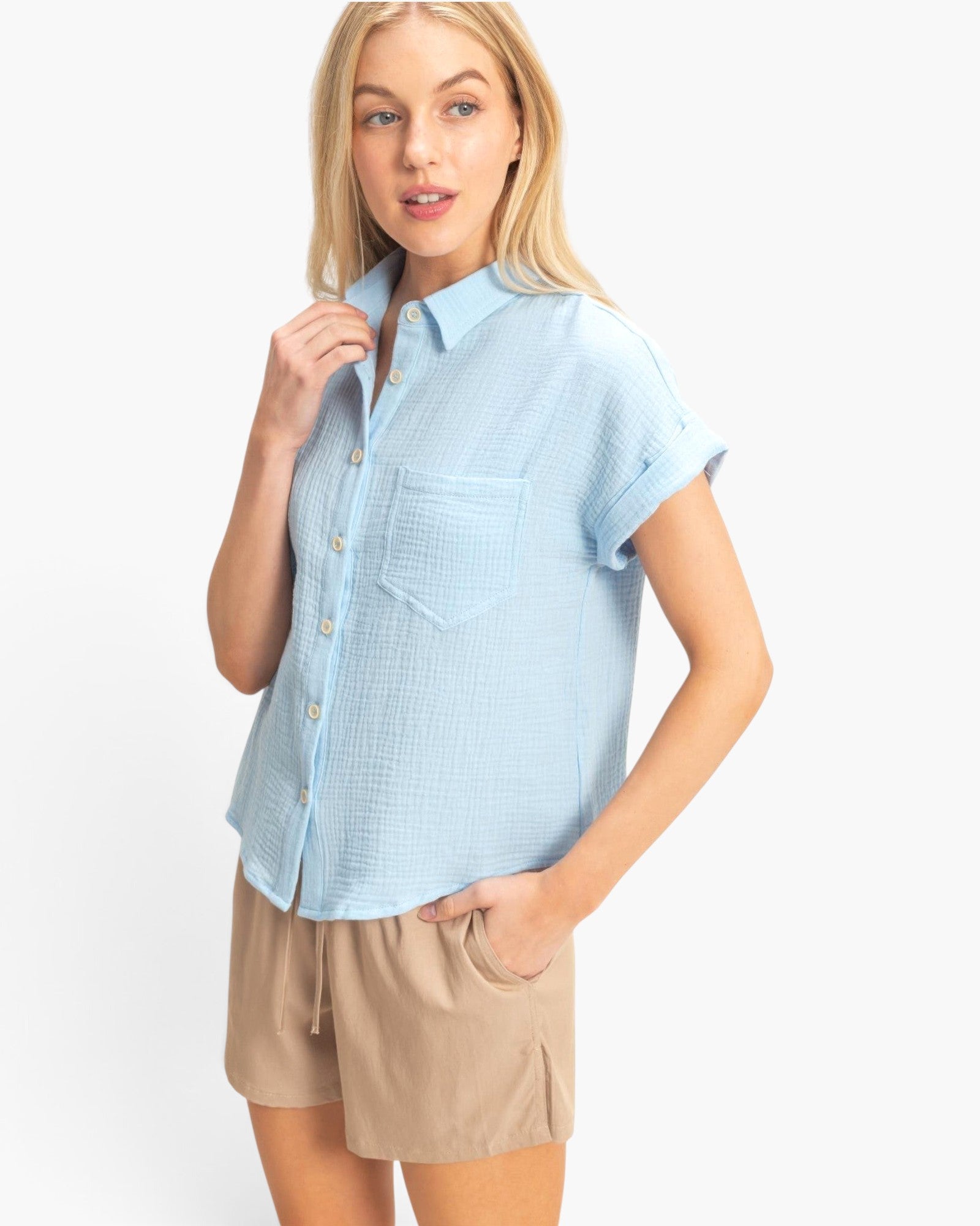 Beach Rose Co. light blue cotton button-up top with rolled sleeves and chest pocket worn by a blonde model